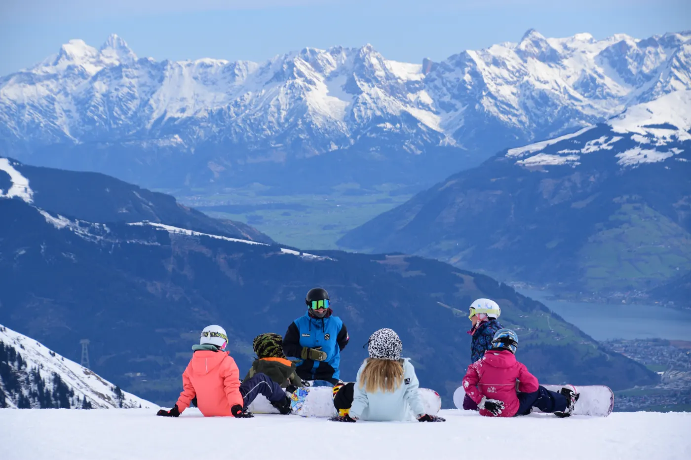 Kouč s dětmi na svahu nad údolím Zell am See